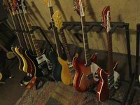 Gareth's stable of Basses on the left rack including the Lemmy on the far left ... and Kira's collection on the right rack... the refinished 2030 bass, her blonde 325, the Carl Wilson and the sweet Ruby 320 with Checkered bound headstock