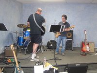 Rich explaining a drum part opening to Pete, with Harry trying out Woody's Fretless converted 4004.  THe FireGlo six string on the right is Gary's.   (photo courtesy of Gary modrock)