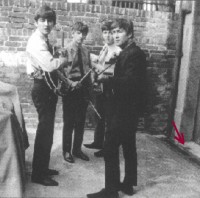 Ringo is still in a fighting mood (as can be seen by the expression on his face)<br />in this famous photo where his bandmates try desperately to calm him down.<br />Recent forensic tests have proved that the stain on the step is actually blood <br />from Andy White's shattered leg. [see arrow]