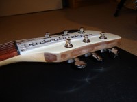 The edge of the headstock is bare wood, just like the neck.