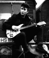 1960. John Lennon in Hamburg on a fairground, near the Reeperbahn, <br />called "Heiligengeistfeld". His guitar is still unmodified.  This was taken<br />during the Oct 4 - Nov 30 1960 Hamburg stay.