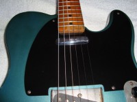 A bakelite pickguard with the neck pickup screws hidden