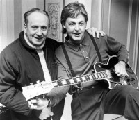 Paul McCartney, right, tries out a custom-made left handed "Les Paul Lite" guitar presented to him by designer Les Paul in 1988