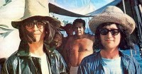 The caption for this photo read "When George, Pattie, Cynthia and John all went on their Tahiti trip together, John and George donned wigs(that the girls had used previously for disguises), hats and raincoats and made a wacky home movie about a missionary (John) who rises from the water to save the heathen natives. Oh, how I wish this film would turn up someplace.It would be the ultimate YouTube experience."