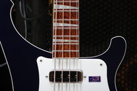 The strings are not centered over the pole pieces or on the fret board (biased towards the G string) because of the bridge saddles.